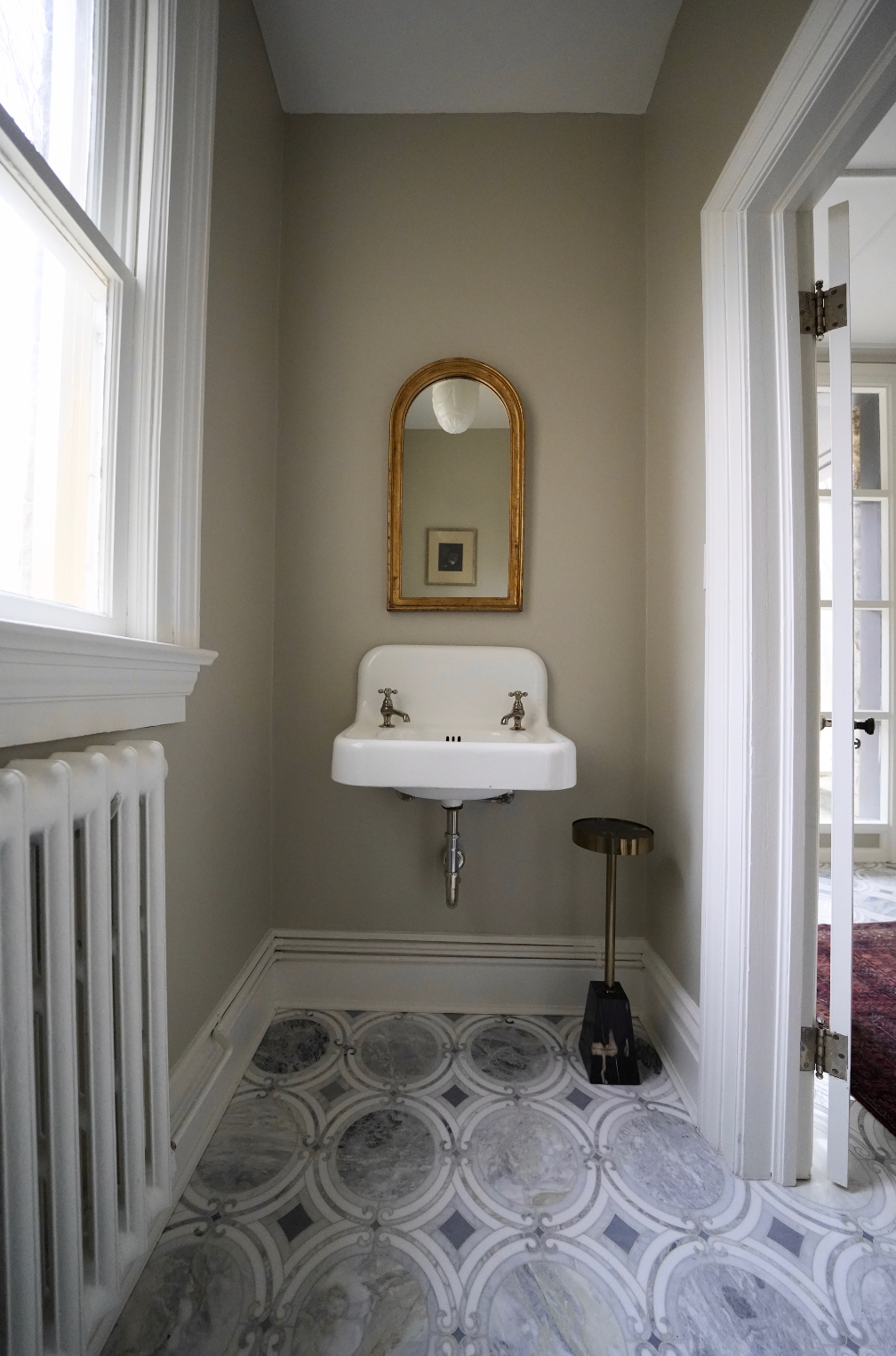 Bathroom with white sink, mirror, and patterned floor tiles.